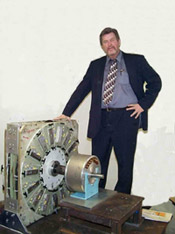 Dennis Lee Standing with Hummingbird Magnetic Motor and Sundance Generator